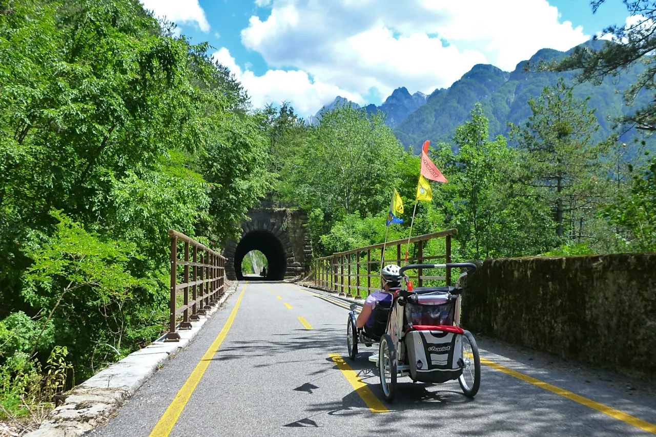 Ciclista con carrello portabimbi sulla Ciclovia Alpe Adria
