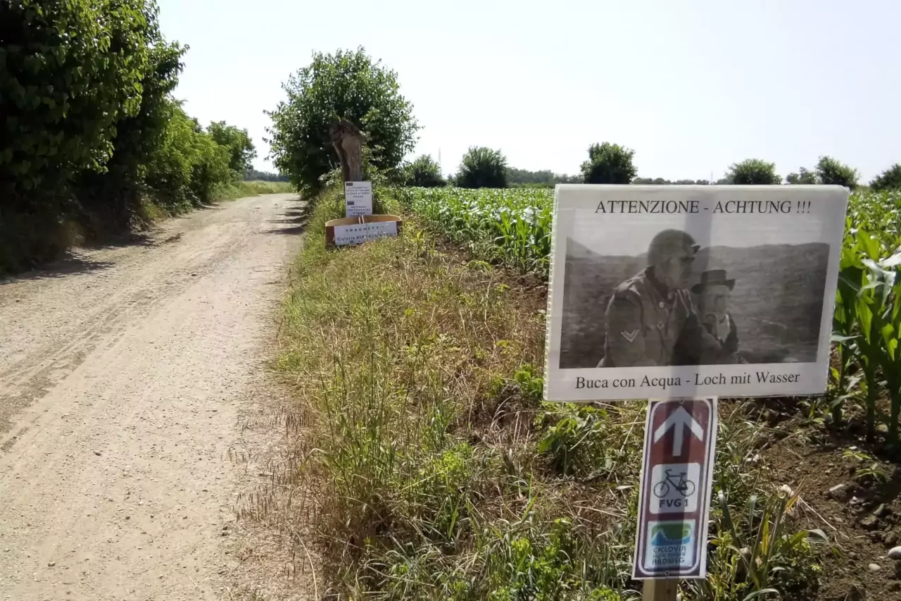 I cartelli burloni posizionati presso l'enorme pozzanghera che qui si formava dopo le piogge