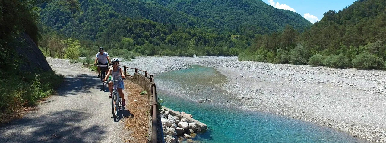 Cyclists follow the Tagliagliamento river in the Carnic Alps